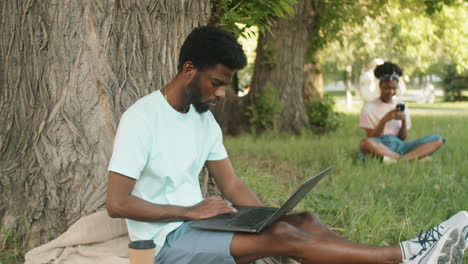 Junger-Afroamerikanischer-Mann-Benutzt-Laptop-Im-Park